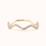 A gold band ring with a wave-like design, set with lab-grown diamonds.
