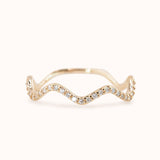 A gold band ring with a wave-like design, set with lab-grown diamonds.